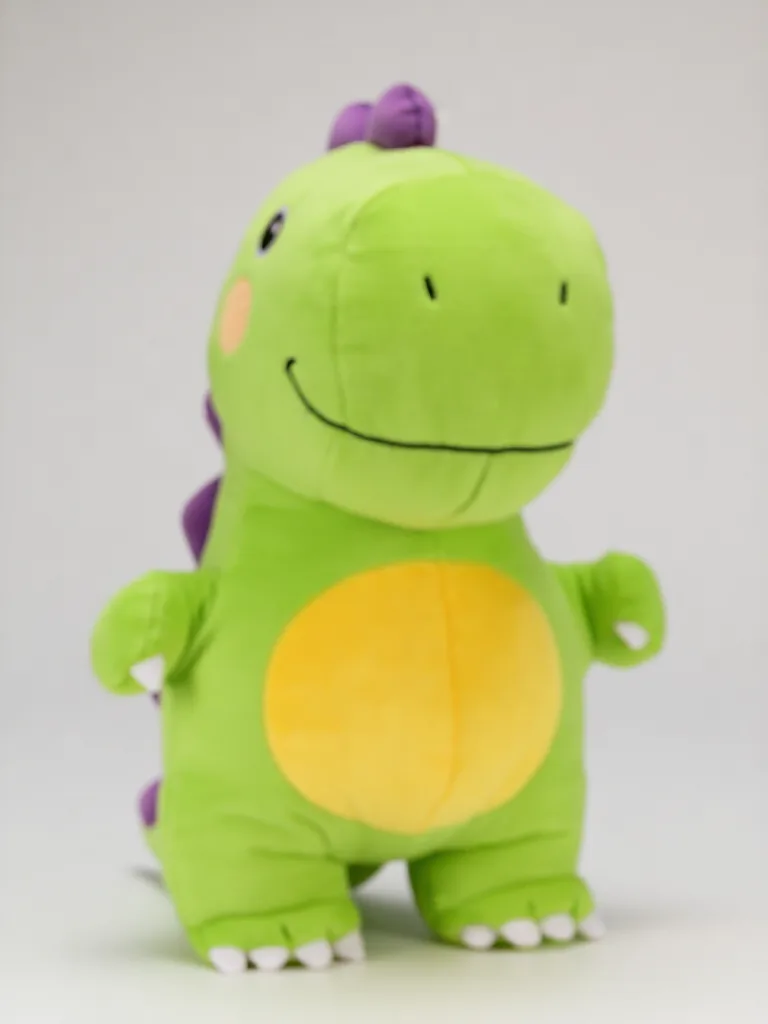 A lime-green dinosaur plush with a yellow belly, tiny arms and purple back spikes